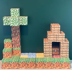 a house made out of lego blocks on top of a pile of money in front of a green wall