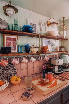 a kitchen counter topped with lots of plates and bowls next to a shelf filled with dishes