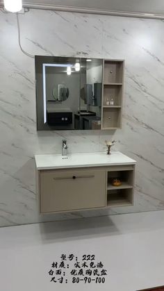 a bathroom with marble walls and white counter tops, an illuminated mirror above the sink