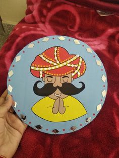 a hand holding up a cartoon plate with a mustache on it's face and an image of a man wearing a red hat