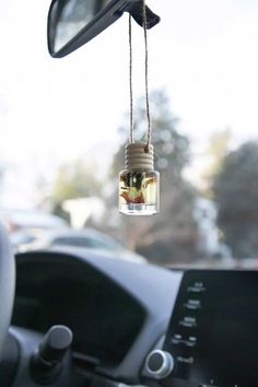 a car dashboard with a bottle hanging from the ceiling