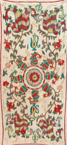 an embroidered cloth with red, green and blue flowers on white background is featured in this image