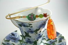 a tea cup and saucer on a plate with a gold handled spoon in it