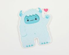 a blue sticker with an image of a monster holding a heart on it's chest