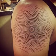 a person with a tattoo on their arm has a circular design in the middle of it