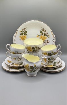 a yellow and white china set with roses on it