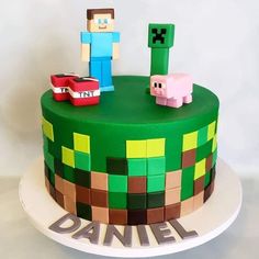 a green cake decorated with legos and animals on top of the cake is minecraft characters