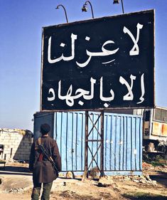 a man standing in front of a large sign with writing on it's side