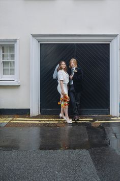 a man and woman standing in front of a garage door