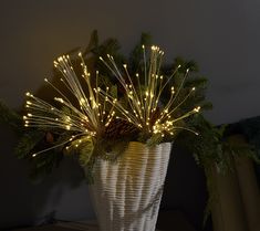 a white vase filled with lots of christmas lights