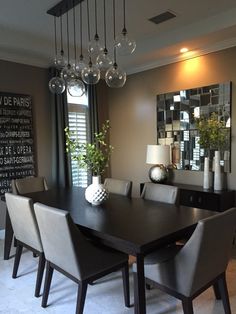 a dining room table with chairs and a mirror on the wall in front of it