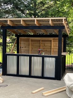 an outdoor bar is built into the side of a fenced in area with wood slats