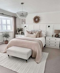 a bedroom with white furniture and neutral colors