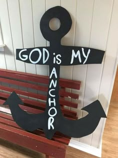 a wooden anchor with the words god is my anchor painted on it sitting on a bench