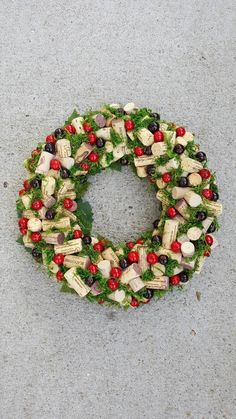 a wreath made out of wine corks and other things on the ground with red berries