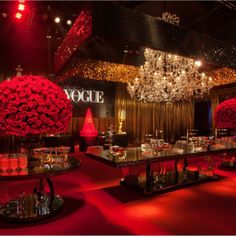 a red carpeted room with chandeliers and flower centerpieces on the tables