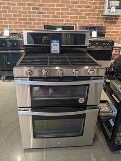 two ovens are sitting next to each other in a room with brick walls and flooring