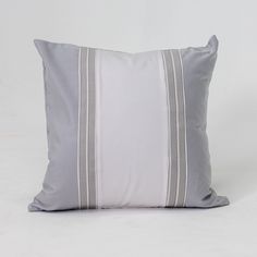 a gray and white pillow with two stripes on the front, sitting against a white background