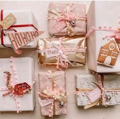 there are many wrapped presents on the table together, including pink and gold wrapping paper