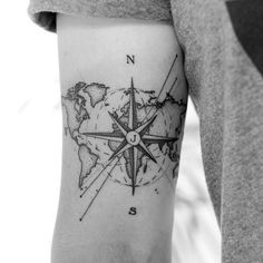 a man with a compass tattoo on his arm