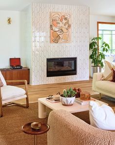 a living room filled with furniture and a fire place in the middle of a room