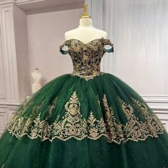 a green and gold ball gown on display in a room with white trimmings