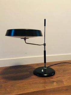 a black lamp sitting on top of a wooden floor