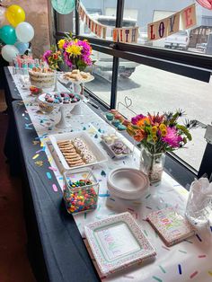 a table set up for a birthday party with confetti, cookies and desserts