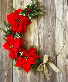 a christmas wreath with poinsettis and greenery on a wooden background, top view