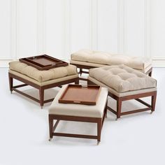 a set of four foot stools and ottomans with tray on each one side