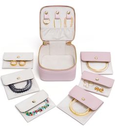 an assortment of jewelry and bracelets in a pink case on a white surface with other accessories