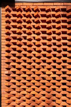 a red brick wall that is made out of bricks and has many small holes in it