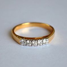 a three stone diamond ring on a white surface