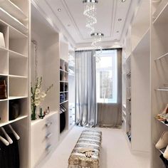 a walk in closet filled with lots of white shelves and shoes on top of them