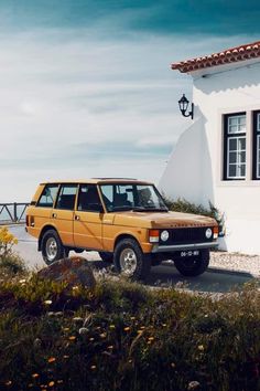 an orange car parked in front of a white building