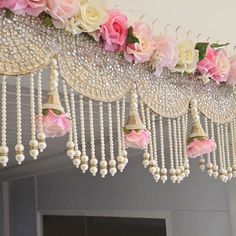 the flowers are hanging from the ceiling with bells and pearls on it's side