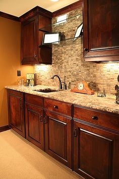 a kitchen with wooden cabinets and marble counter tops