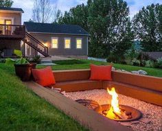 a fire pit in the middle of a yard with stairs leading up to it's second story