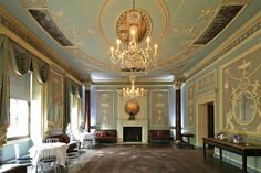 an ornate room with chandelier and chairs