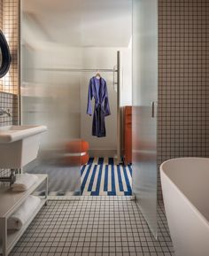 a bath room with a tub a sink and a towel hanging on a rack in it