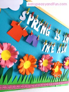 spring is in the air bulletin board with paper flowers and clothes pegs on it