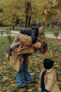 a mother and her child playing in the leaves