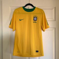 a soccer jersey hangs on a door hanger in front of a white door with a green and yellow stripe