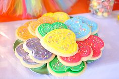 there are many decorated cookies on the table with candy in the backgrouds