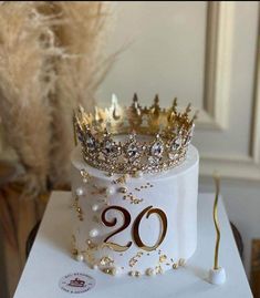 there is a cake with a crown on top and pearls around the edges that says 20th