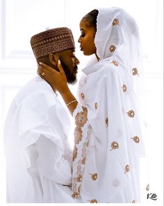 a man and woman dressed in white standing next to each other with headscarves on