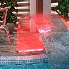 an indoor swimming pool with a water feature in the center and red lights on it