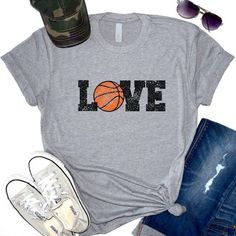 a t - shirt that says love with a basketball on the front and sunglasses next to it