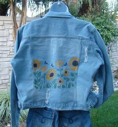 Add this beautiful Ladies XL Blue Jean Jacket Up Cycled Altered Distressed Stenciled Sunflowers to your wardrobed or give it as a gift to someone special. I up cycled/altered this blue jean jacket by stenciling it with yellow sunflowers. The design was heat set. Factory distressing. The jacket is and extra large.  Approximate measurements: Waist band: 44 inches Chest:49 inches Neck to hem: 21 1/2  inches Arm length: Shoulder seam to cuff 25 1/2 inches Recommend cold water wash, gentle cycle with the garment inside out. Hang to dry. Blue Cotton Floral Print Outerwear, Blue Floral Print Cotton Outerwear, Blue Floral Denim Outerwear, Jeans Jacket Painted, Painting Jeans, Jean Art, Diy Denim Jacket, Diy Denim, Diy Jeans