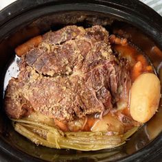 a pot roast with potatoes and carrots in the slow cooker, ready to be cooked